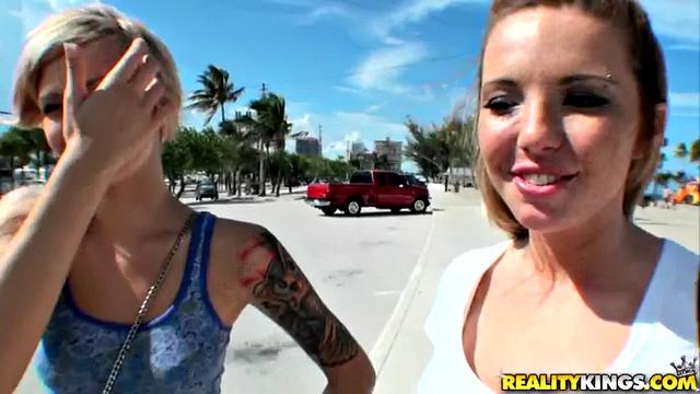 Blonde tattooed lesbians smile and lick each other's small tits outdoors
