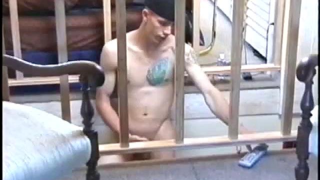 Dressed in very baggy shorts and a baseball cap, Shane stands halfway up a short stairway, watching his porn video while talking about making the wall the target for his cum shot.