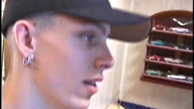 Dressed in very baggy shorts and a baseball cap, Shane stands halfway up a short stairway, watching his porn video while talking about making the wall the target for his cum shot.