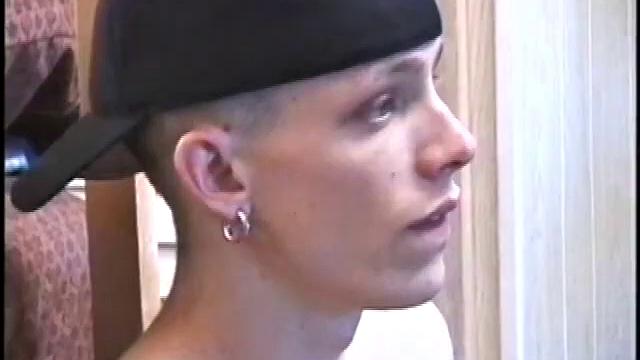 Dressed in very baggy shorts and a baseball cap, Shane stands halfway up a short stairway, watching his porn video while talking about making the wall the target for his cum shot.