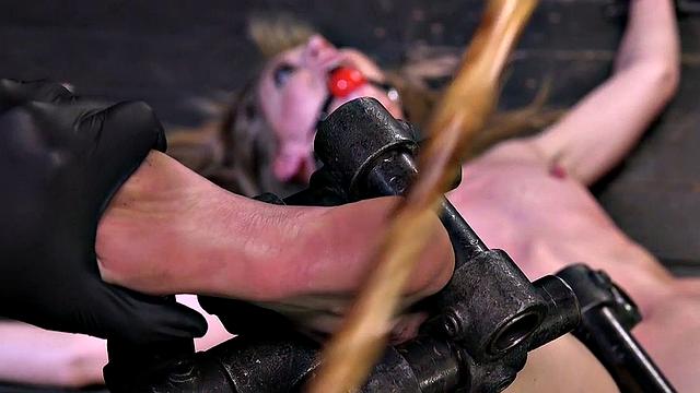 BDSM sub screams from pain as her master whips her feet
