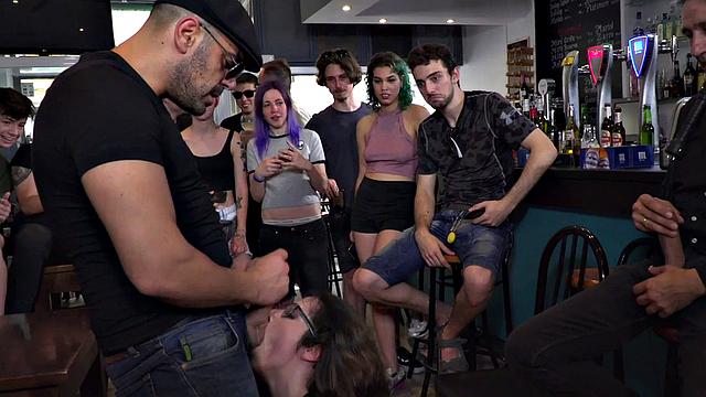 Public BDSM babe deepthroats hard cock in front of onlookers