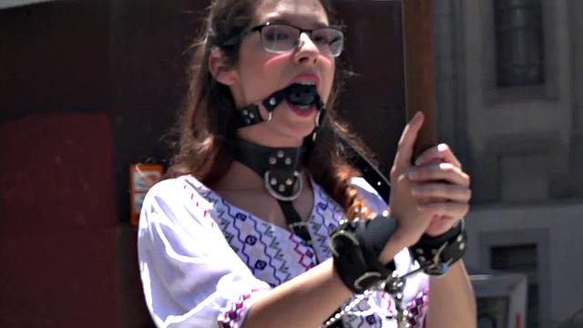 Public BDSM babe deepthroats hard cock in front of onlookers