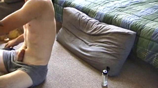 Dan gets down on the floor and starts watching a porn video. He goes right for his cock and plays with himself until he's boned up. Rolling the head with his palm, Dan lubes up his hot dick.