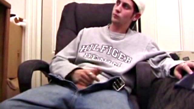 As a porn flick plays, young amateur Aaron Michaels strokes hard, pulls his cock out of his jeans, lets loose, and spills his nut on the bed.