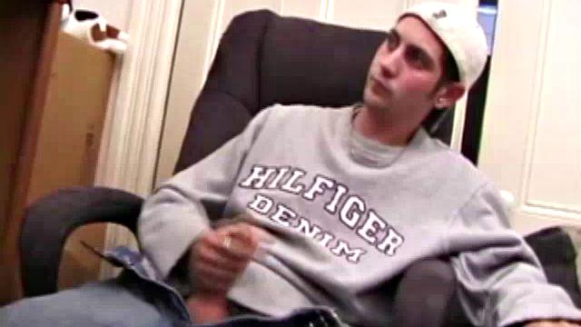 As a porn flick plays, young amateur Aaron Michaels strokes hard, pulls his cock out of his jeans, lets loose, and spills his nut on the bed.