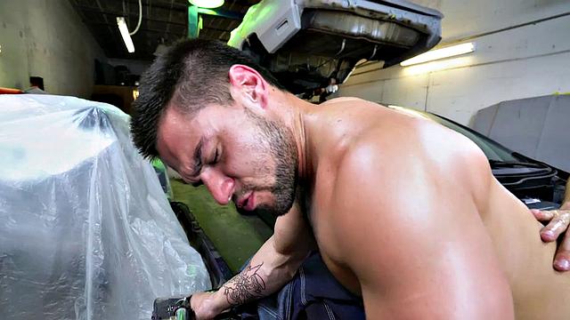 Tattooed stud in the ass fucks muscular nympho in a bareback garage doggystyle