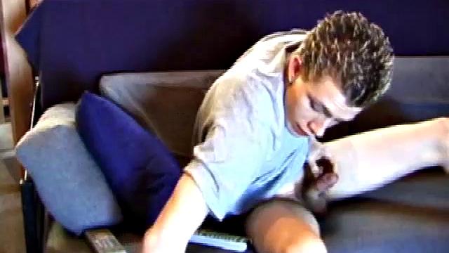 Shane relaxes on the couch, while watching a porn video and gets totally into himself. He works his lubed up cock with determination and pumps out a big cum shot.