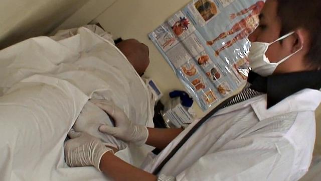 Asian stud gets a thorough check-up before being bred by medic in uniform