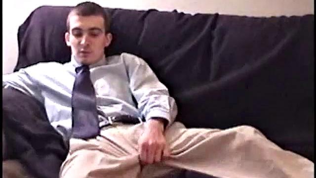 Darrell kicks back on the sofa, makes himself comfortable, rubs his package to work up a bulge, and then releases a big cock. At the same time, he pulls off his dress shirt and tie.