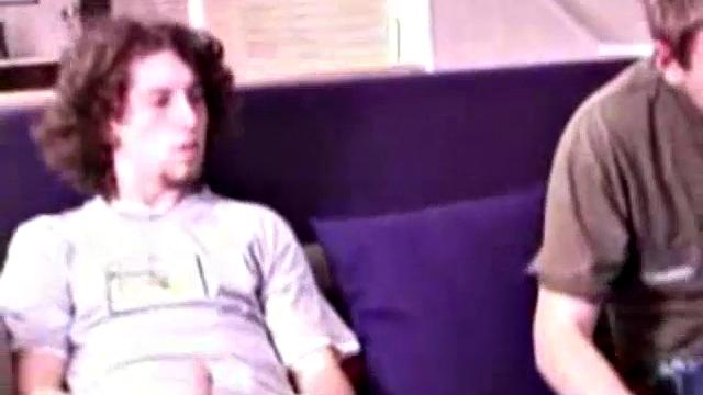 Adam and Christian sit next to each other on the couch watching a porno. They unzip and stoke for a bit, before taking turns sucking each other's hard cock.