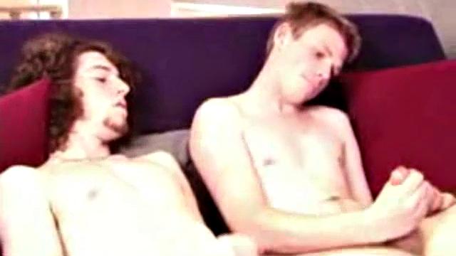 Adam and Christian sit next to each other on the couch watching a porno. They unzip and stoke for a bit, before taking turns sucking each other's hard cock.