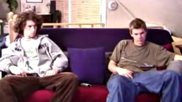 Adam and Christian sit next to each other on the couch watching a porno. They unzip and stoke for a bit, before taking turns sucking each other's hard cock.