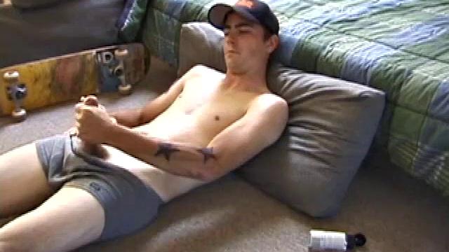 Dan gets down on the floor and starts watching a porn video. He goes right for his cock and plays with himself until he's boned up. Rolling the head with his palm, Dan lubes up his hot dick.