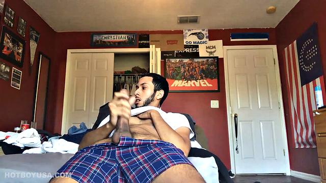 While watching a porn video, Brian kicks back, pushes his pants down and pulls his stiff dick out of the fly of his boxers. After a little stroking he pushes the underwear down to release his balls.