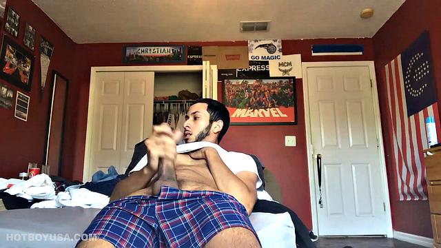 While watching a porn video, Brian kicks back, pushes his pants down and pulls his stiff dick out of the fly of his boxers. After a little stroking he pushes the underwear down to release his balls.