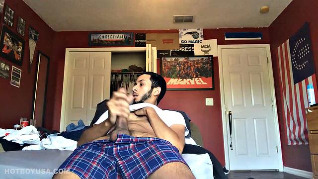 While watching a porn video, Brian kicks back, pushes his pants down and pulls his stiff dick out of the fly of his boxers. After a little stroking he pushes the underwear down to release his balls.