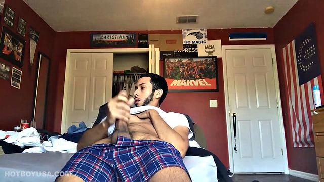 While watching a porn video, Brian kicks back, pushes his pants down and pulls his stiff dick out of the fly of his boxers. After a little stroking he pushes the underwear down to release his balls.