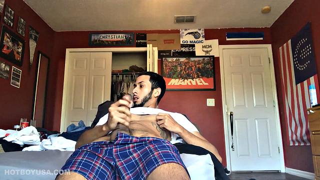 While watching a porn video, Brian kicks back, pushes his pants down and pulls his stiff dick out of the fly of his boxers. After a little stroking he pushes the underwear down to release his balls.