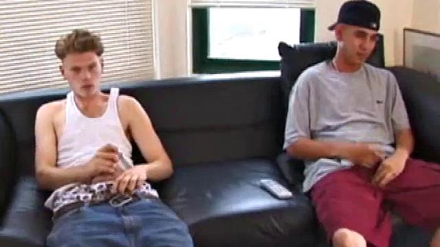 Christian and Richie sit on the sofa, watching a porn video while slowly rubbing their crotches. Richie shyly takes out his dick and watches as Christian strips off his shorts and exposes an impressive cock.
