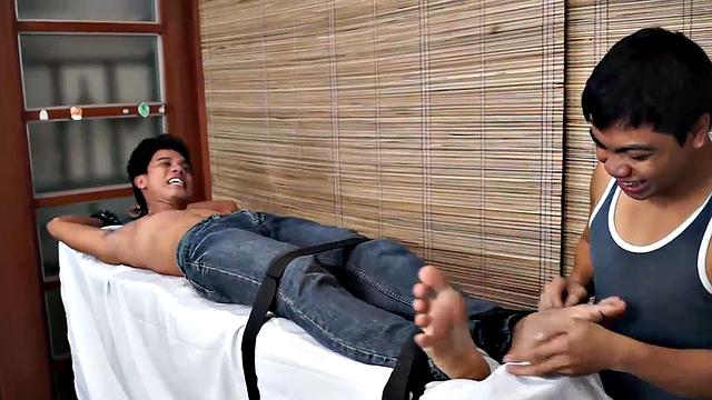 Sexy Asian boy Simon fits perfectly on our tickle rack, as if made for him. Vahn straps him down and starts lightly tickling with the big blue ostrich plume.