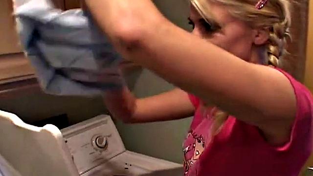 Blonde teen with small tits gets fingered in the laundry room while wearing a t-shirt and a pigtail
