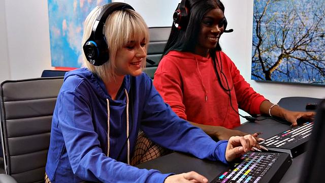 Ebony gamer shares double dildo with white GF on table