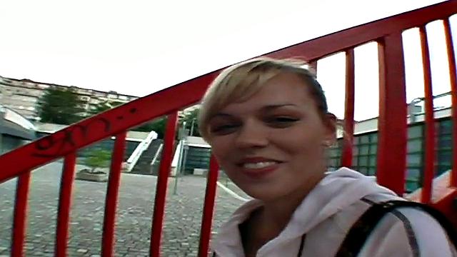 Watch this blonde hottie in a tight skinny top suck and lick a big dong outdoors