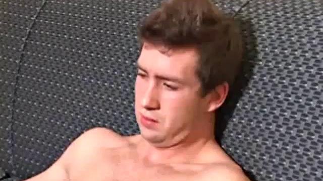 Donovan Woodside works up his boner on sofa with serious stroking and ass play, ending in warm cum