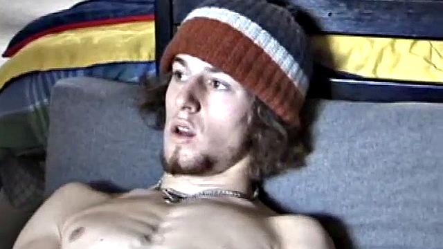 Adam relaxes on the floor watching porn video, strokes cock, plays with butthole, and blasts cum load onto skateboard