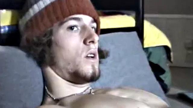 Adam relaxes on the floor watching porn video, strokes cock, plays with butthole, and blasts cum load onto skateboard