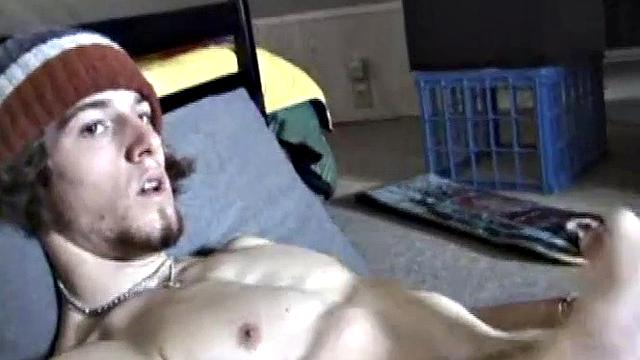 Adam relaxes on the floor watching porn video, strokes cock, plays with butthole, and blasts cum load onto skateboard