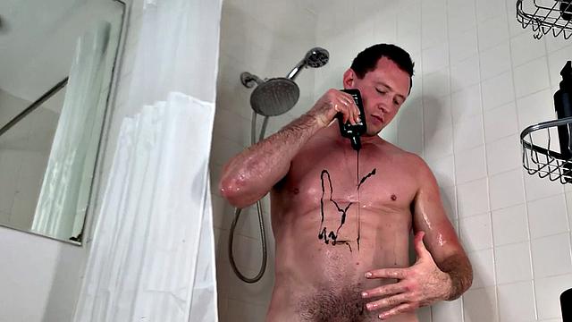 Soapy gay man jerks his hard cock in close bathtub scene