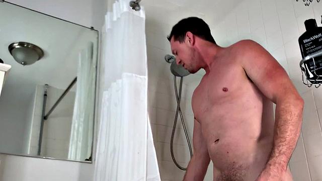 Soapy gay man jerks his hard cock in close bathtub scene
