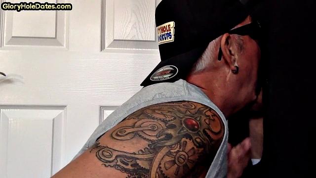 Tattooed DILF sucks gloryhole penis with his jizzed mouth