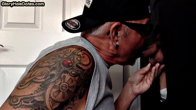 Tattooed DILF sucks gloryhole penis with his jizzed mouth