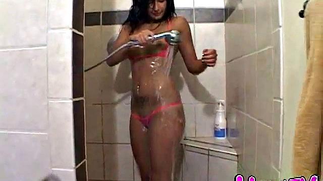 Naked brunette teen fingers her pussy in shower