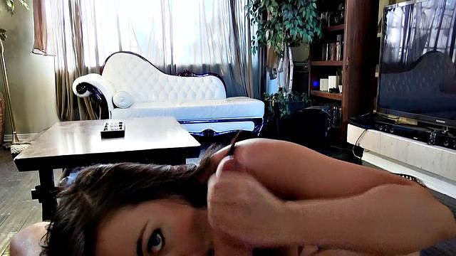 Watch this brown-haired babe give a hot handjob & get a facial in the living room