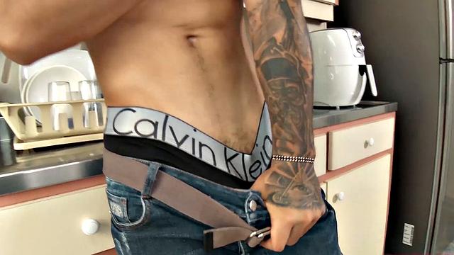 We find Julian in the kitchen, as his clothes slowly hit the floor. He pushes his pants and underwear down and a big boner pops out. Once Julian is completely naked, he leans against a counter and starts jacking off.