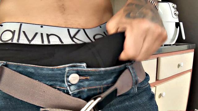 We find Julian in the kitchen, as his clothes slowly hit the floor. He pushes his pants and underwear down and a big boner pops out. Once Julian is completely naked, he leans against a counter and starts jacking off.