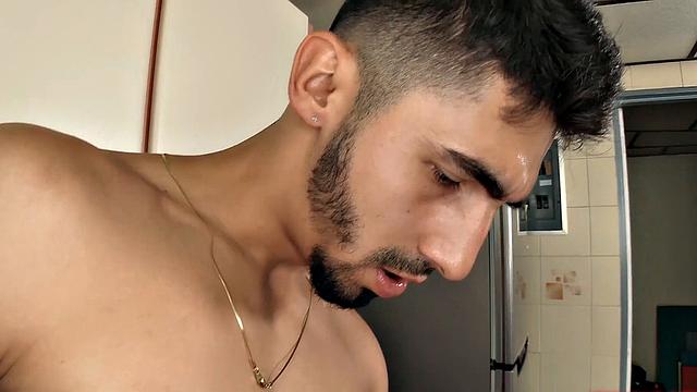 We find Julian in the kitchen, as his clothes slowly hit the floor. He pushes his pants and underwear down and a big boner pops out. Once Julian is completely naked, he leans against a counter and starts jacking off.