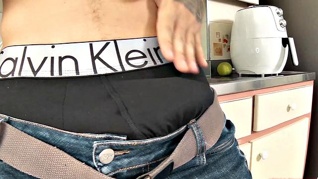 We find Julian in the kitchen, as his clothes slowly hit the floor. He pushes his pants and underwear down and a big boner pops out. Once Julian is completely naked, he leans against a counter and starts jacking off.