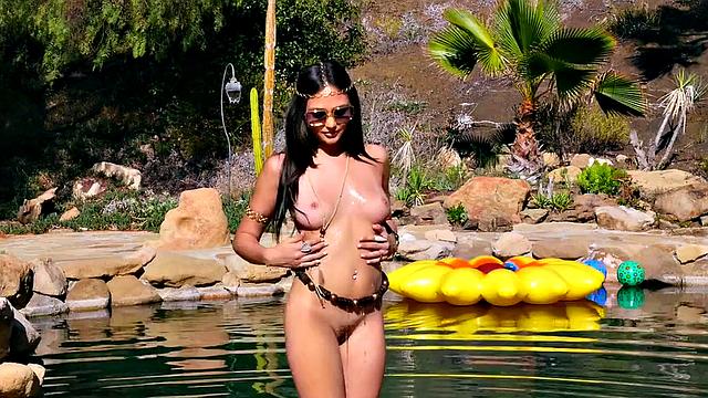 Watch as this tattooed brunette gets off with her glasses on and fingers her trimmed pussy in the pool