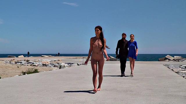 Perky attractive babe walks outdoors naked on the beach