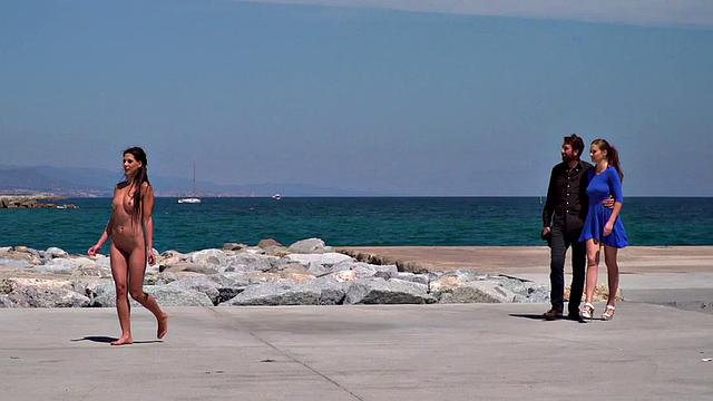 Perky attractive babe walks outdoors naked on the beach