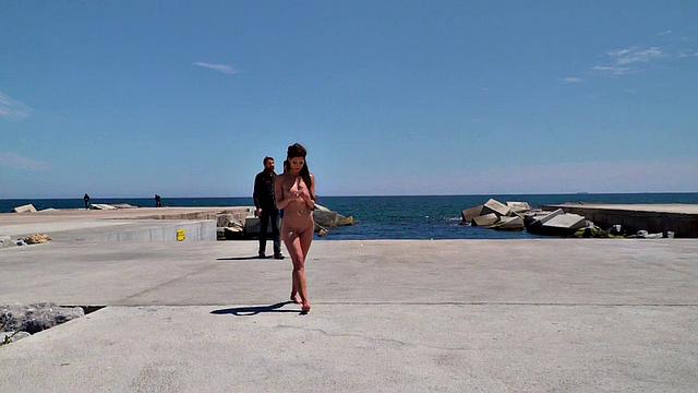 Perky attractive babe walks outdoors naked on the beach