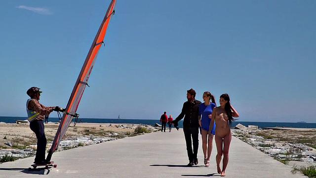 сексуальная брюнетка идет голая по пляжу, собирая восторженные взгляды