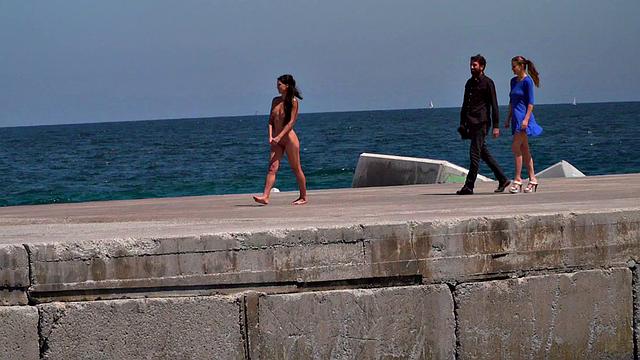 Perky attractive babe walks outdoors naked on the beach