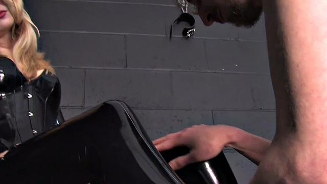 Whipping latex dominatrix pegs sub with strapon in BDSM