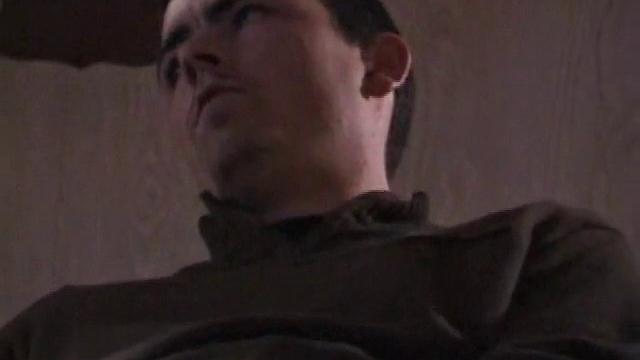 By the time the camera finds him, Dan is already going for his woody. He seems uncomfortable in the chair, so he stands up and moves to the staircase, where we can see his cock getting harder and harder.